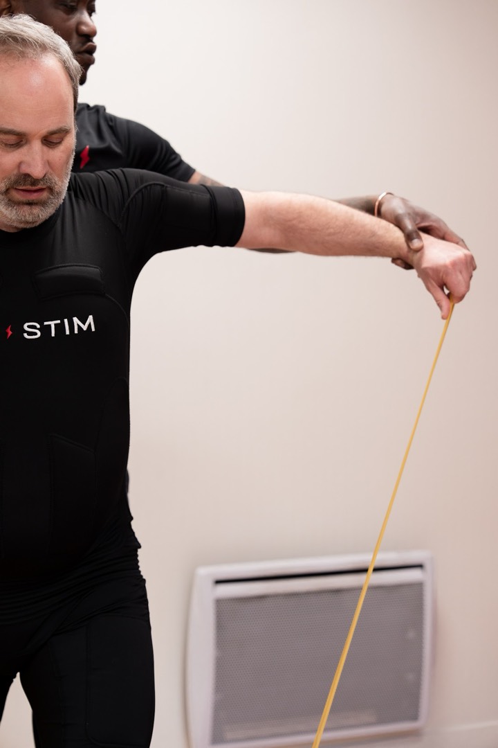 Coach SO STIM encadrant un client en combinaison EMS lors d'une séance semi-privée