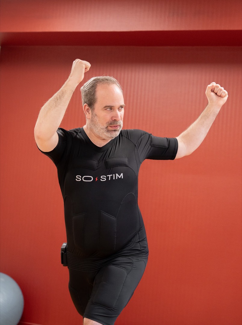 Homme en combinaison EMS, posture énergique pendant une séance d'électrostimulation full-body